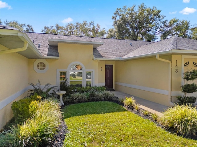 view of exterior entry featuring a yard