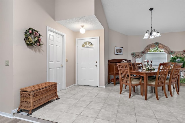 tiled dining area featuring a chandelier and a textured ceiling