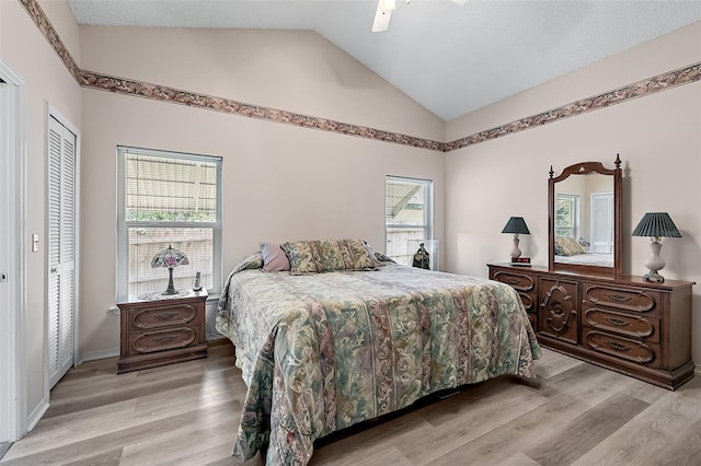 bedroom featuring light hardwood / wood-style floors, a closet, ceiling fan, and vaulted ceiling