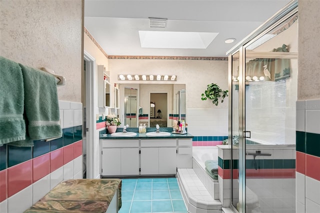 bathroom with vanity, tile patterned floors, a skylight, and plus walk in shower