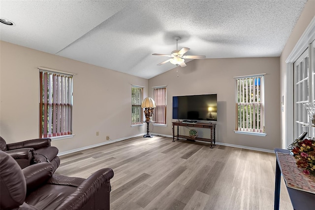 living room with light hardwood / wood-style floors, lofted ceiling, a textured ceiling, and ceiling fan