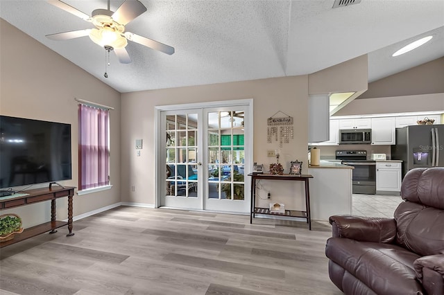 living room featuring light hardwood / wood-style flooring, french doors, ceiling fan, and vaulted ceiling