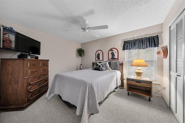 bedroom with light carpet, a textured ceiling, a closet, and ceiling fan