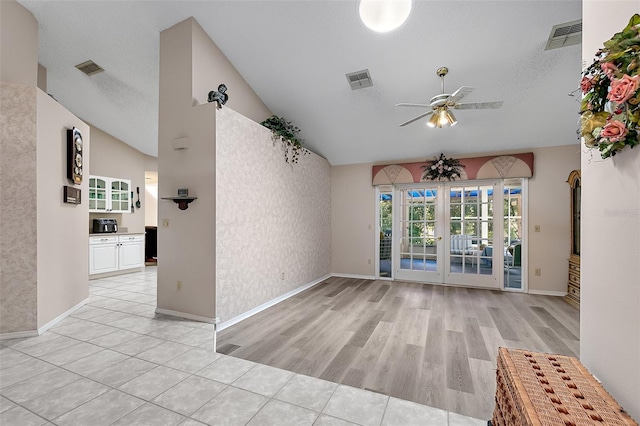 interior space with light hardwood / wood-style floors, a textured ceiling, ceiling fan, and vaulted ceiling