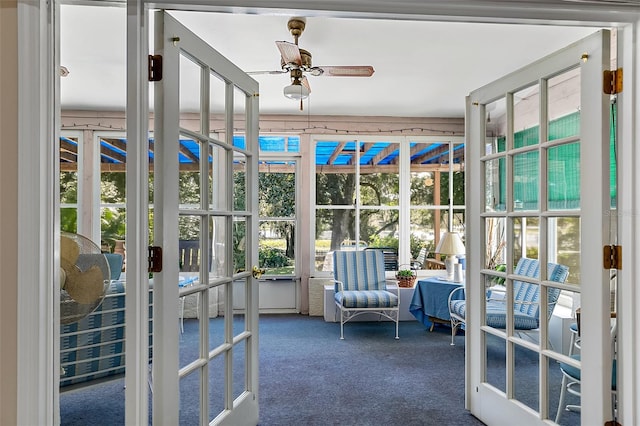 unfurnished sunroom featuring ceiling fan