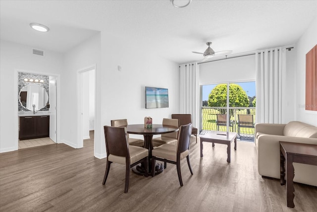 dining space featuring wood-type flooring and ceiling fan