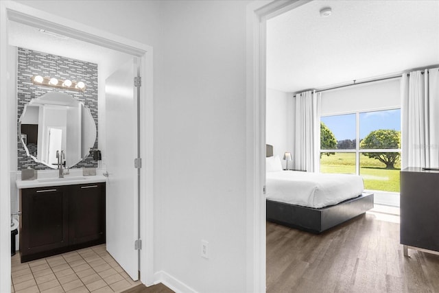 bedroom with sink and light hardwood / wood-style flooring