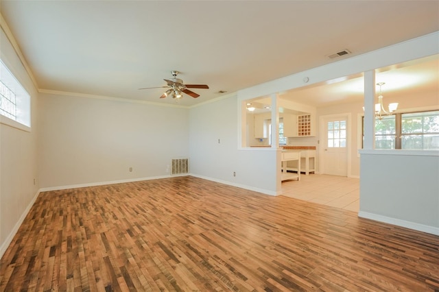 spare room featuring ornamental molding, light hardwood / wood-style flooring, and ceiling fan with notable chandelier