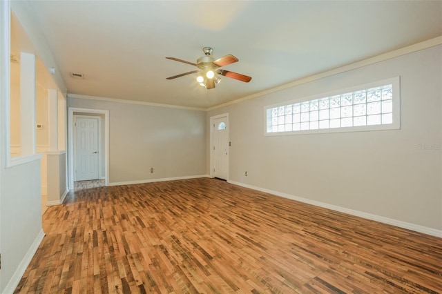 empty room with ceiling fan, crown molding, and hardwood / wood-style floors