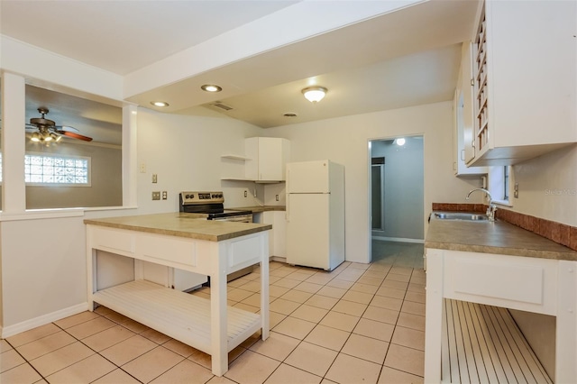 kitchen featuring sink, electric range, white cabinetry, white fridge, and light tile patterned floors