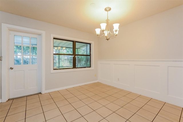 unfurnished dining area with a notable chandelier and light tile patterned flooring