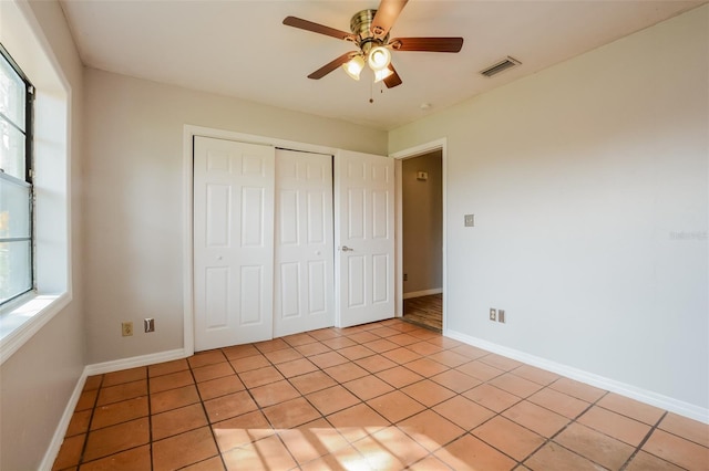 unfurnished bedroom featuring a closet, light tile patterned flooring, and ceiling fan