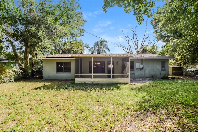 rear view of property featuring a yard and a sunroom