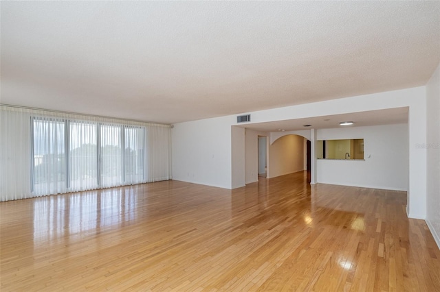 spare room featuring light hardwood / wood-style flooring and a textured ceiling