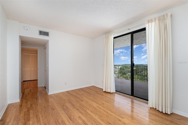 empty room featuring light hardwood / wood-style flooring and a textured ceiling