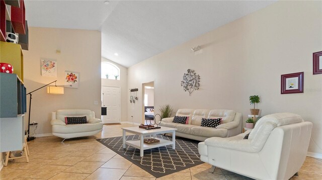 living room featuring high vaulted ceiling and light tile patterned floors