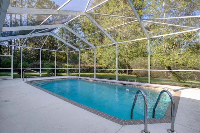 view of pool with a patio area and glass enclosure