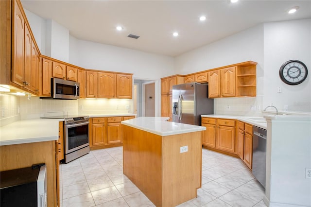 kitchen featuring decorative backsplash, a kitchen island, appliances with stainless steel finishes, light tile patterned flooring, and sink