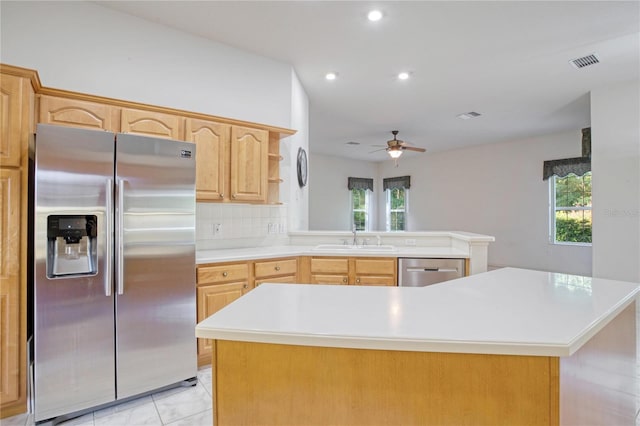 kitchen featuring appliances with stainless steel finishes, light brown cabinets, sink, and a wealth of natural light