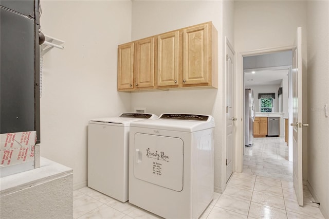 laundry area with cabinets, washer and dryer, and light tile patterned floors