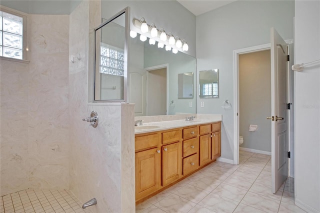 bathroom with vanity, a tile shower, and toilet