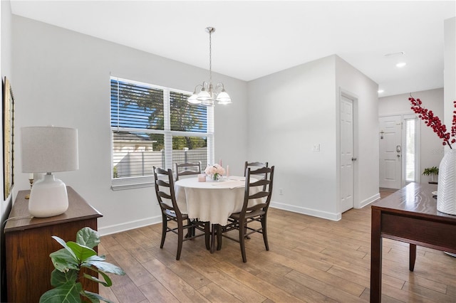 dining room with light hardwood / wood-style floors and a chandelier