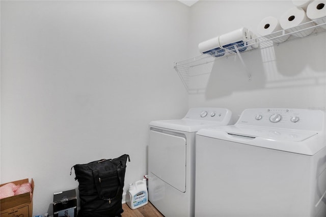 washroom with hardwood / wood-style floors and washing machine and dryer