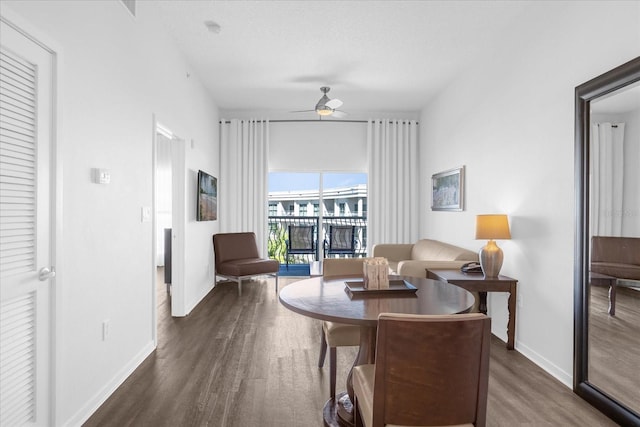 living area with dark wood-type flooring and ceiling fan