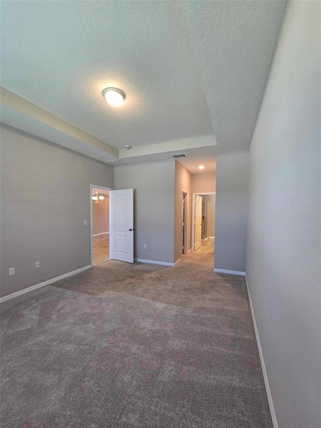 carpeted spare room with a textured ceiling