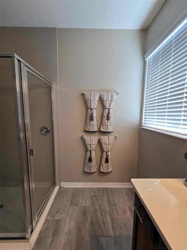 bathroom with a shower with door and vanity