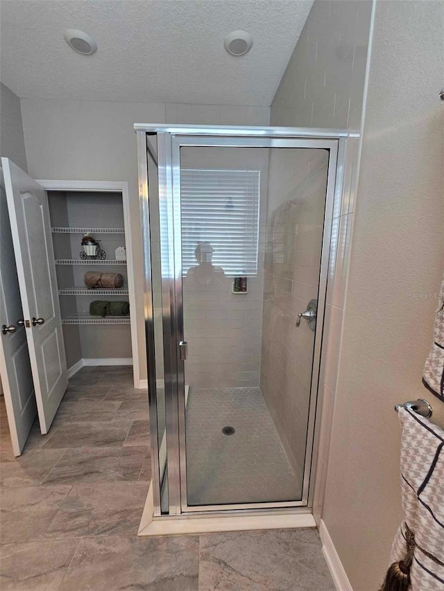 bathroom featuring an enclosed shower and a textured ceiling