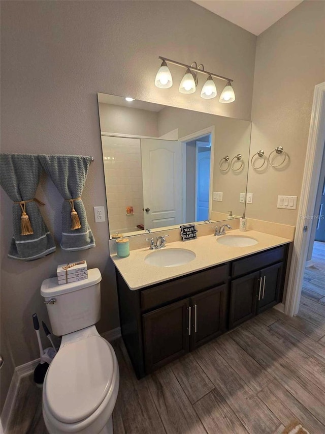 bathroom with wood-type flooring, vanity, and toilet