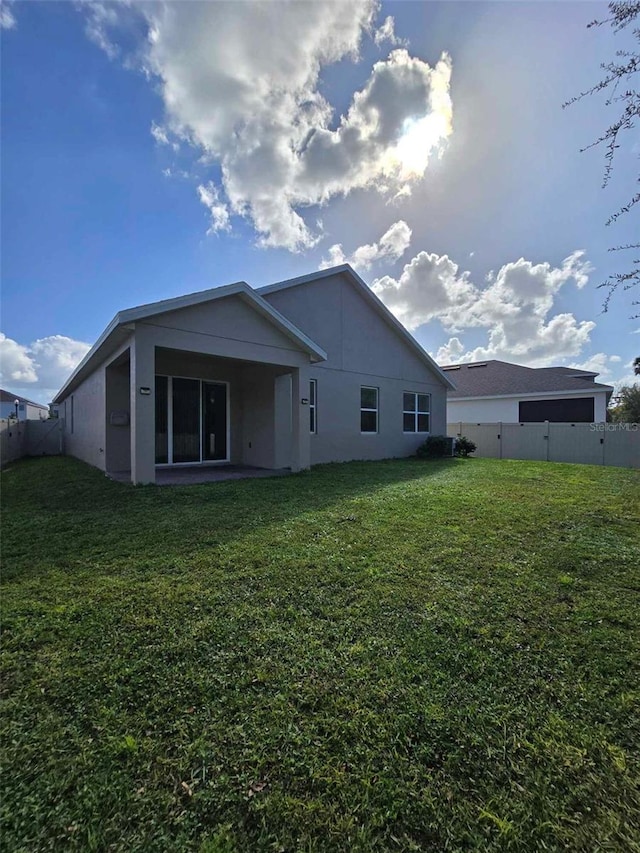 back of house featuring a lawn