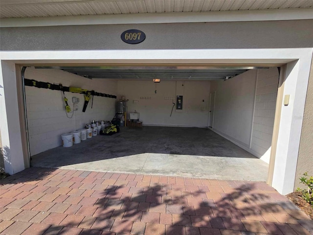 garage featuring electric panel and water heater