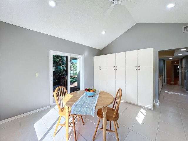 tiled dining space featuring a textured ceiling, high vaulted ceiling, and ceiling fan