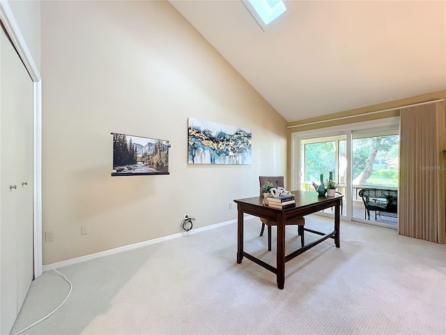 home office featuring a skylight, high vaulted ceiling, and carpet