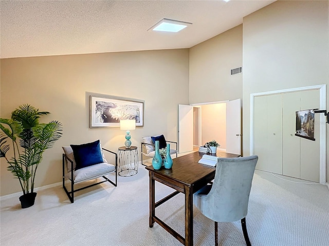 office space with light carpet, a textured ceiling, and high vaulted ceiling