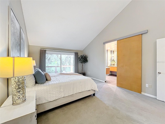 carpeted bedroom with ensuite bath and lofted ceiling