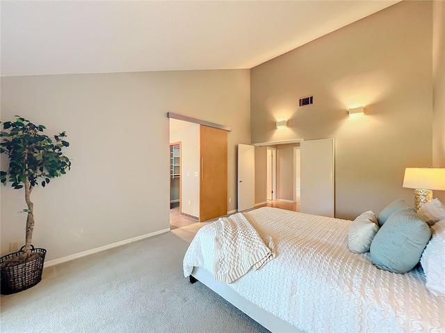 carpeted bedroom with high vaulted ceiling