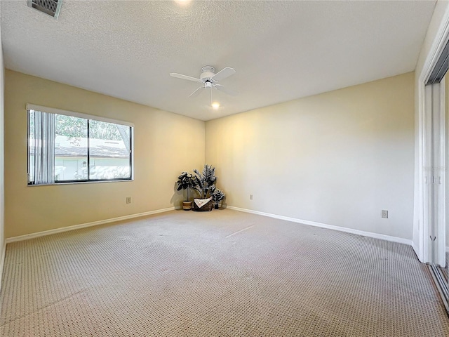 empty room with a textured ceiling, carpet flooring, and ceiling fan