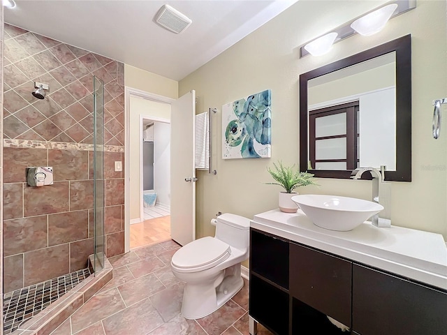 bathroom with vanity, tile patterned floors, toilet, and an enclosed shower