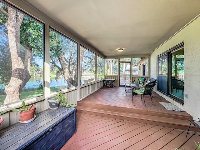 sunroom featuring a water view