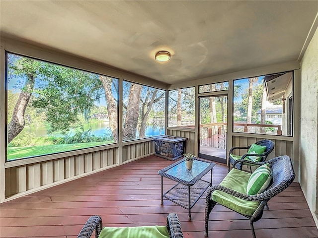 sunroom featuring a water view