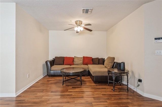 living room featuring a textured ceiling, dark hardwood / wood-style floors, and ceiling fan