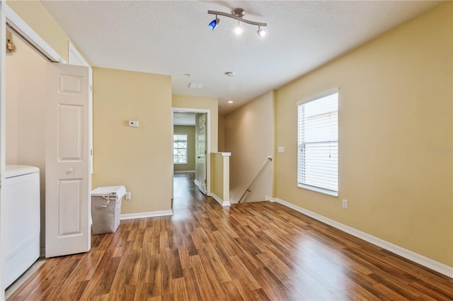 spare room with a textured ceiling, hardwood / wood-style flooring, and plenty of natural light