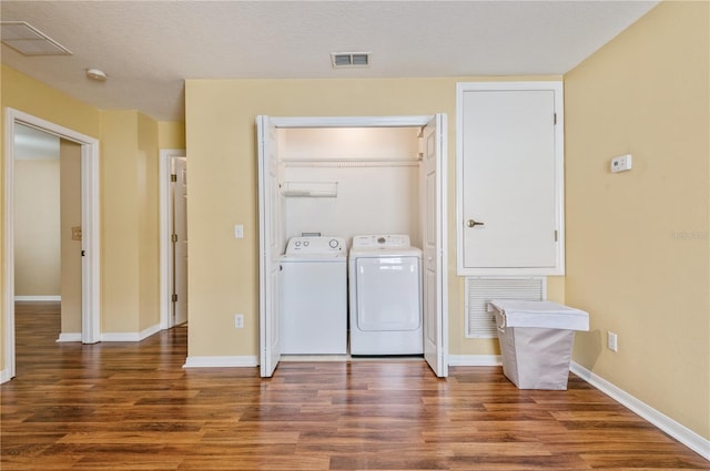 washroom featuring washer and dryer, a textured ceiling, and dark hardwood / wood-style flooring