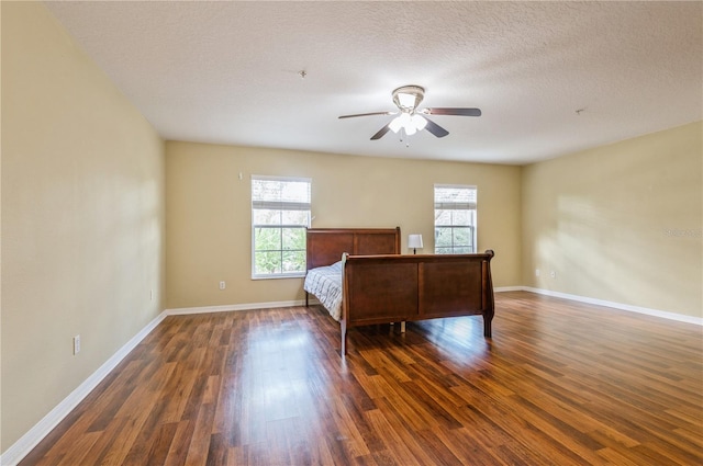 unfurnished bedroom featuring dark hardwood / wood-style floors, a textured ceiling, and ceiling fan