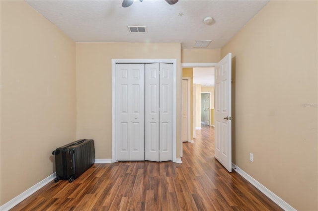 unfurnished bedroom with dark hardwood / wood-style floors, a closet, radiator, a textured ceiling, and ceiling fan