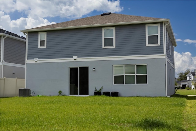 back of property featuring central AC and a lawn