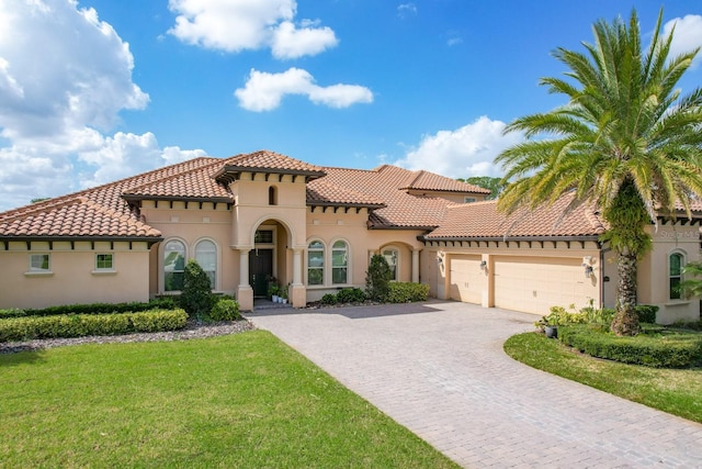 mediterranean / spanish-style house featuring a garage and a front lawn